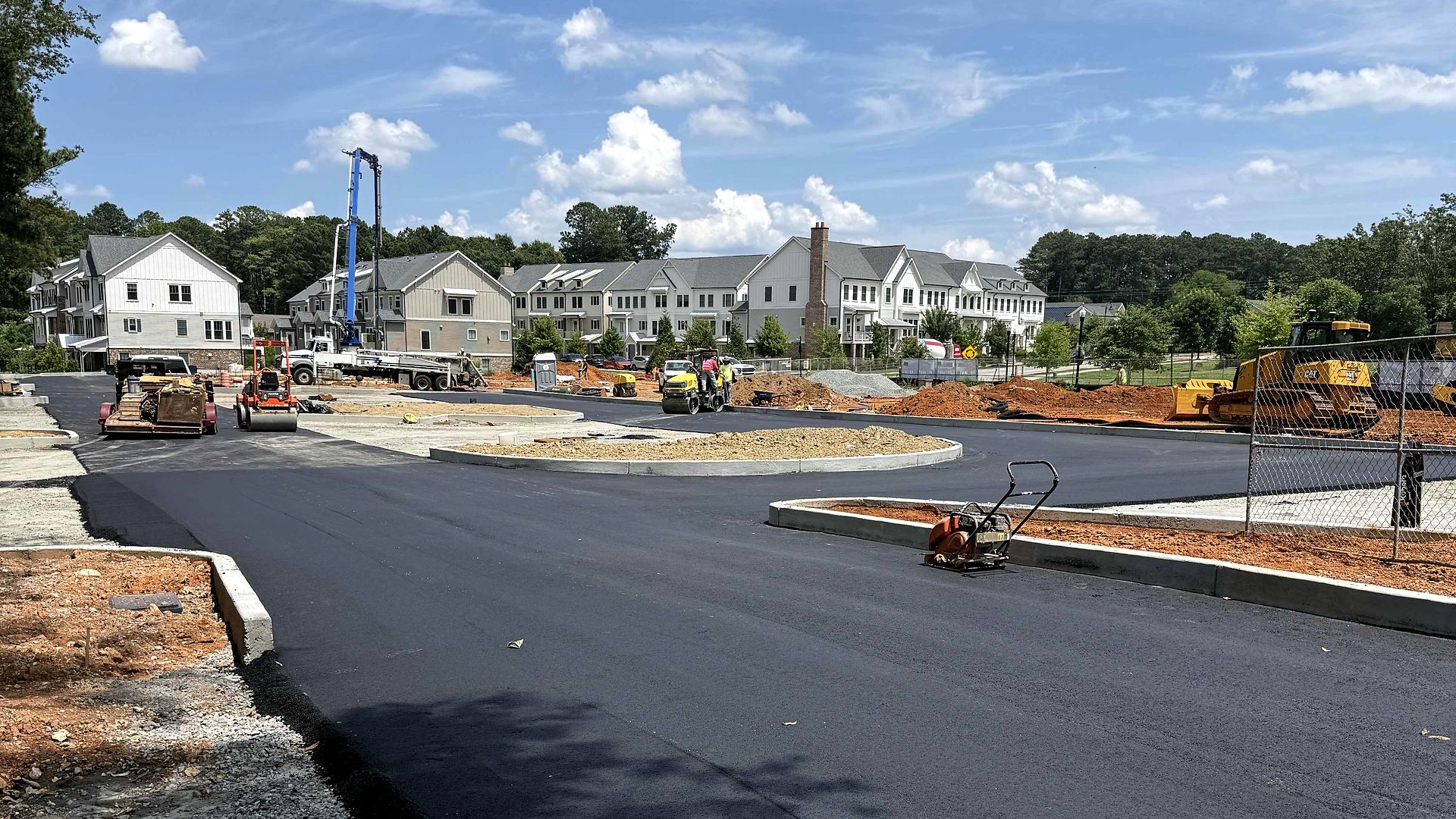 New asphalt paving and concrete curb next to townhomes at Reliant Market District