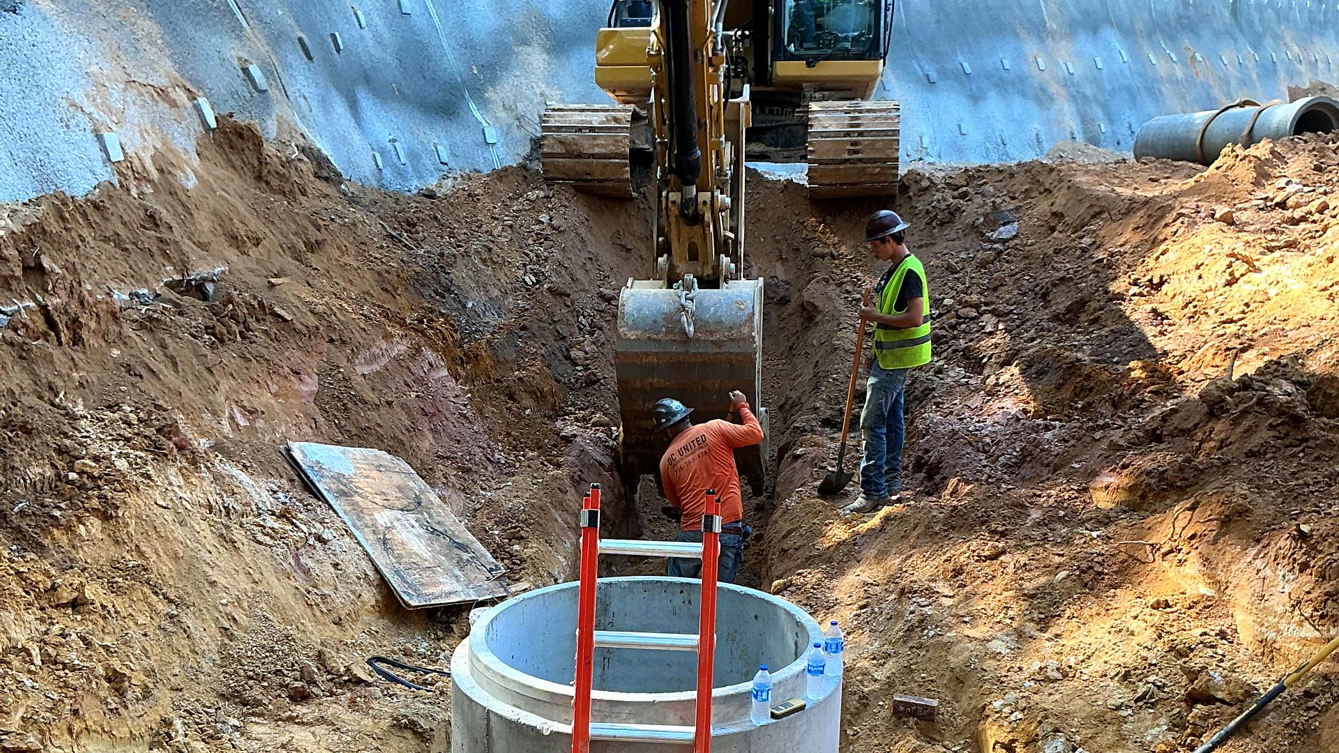 Crew setting a precast manhole on a large pipe in a trench in Bartow County, Georgia