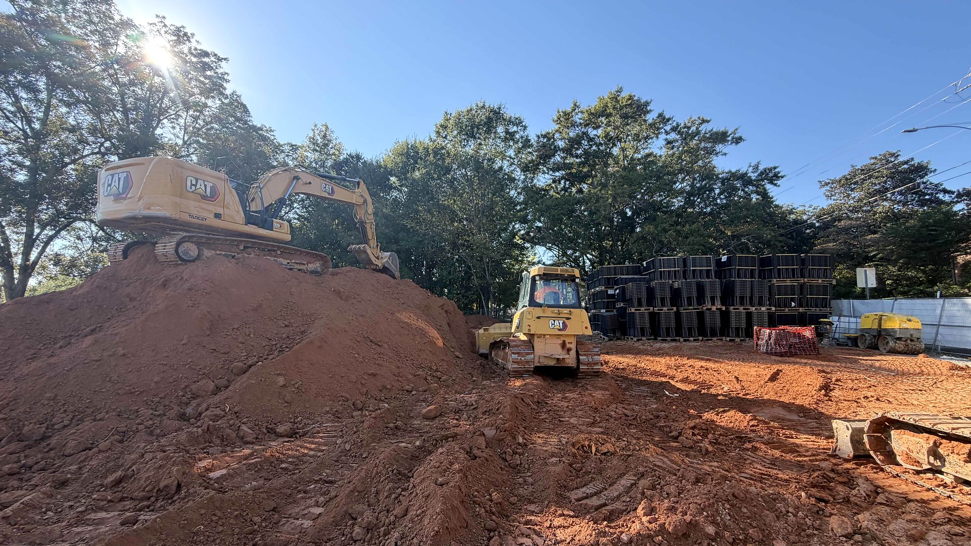 Excavator and dozer working beside stacked underground stormwater modules on a commercial site in Alpharetta, Georgia