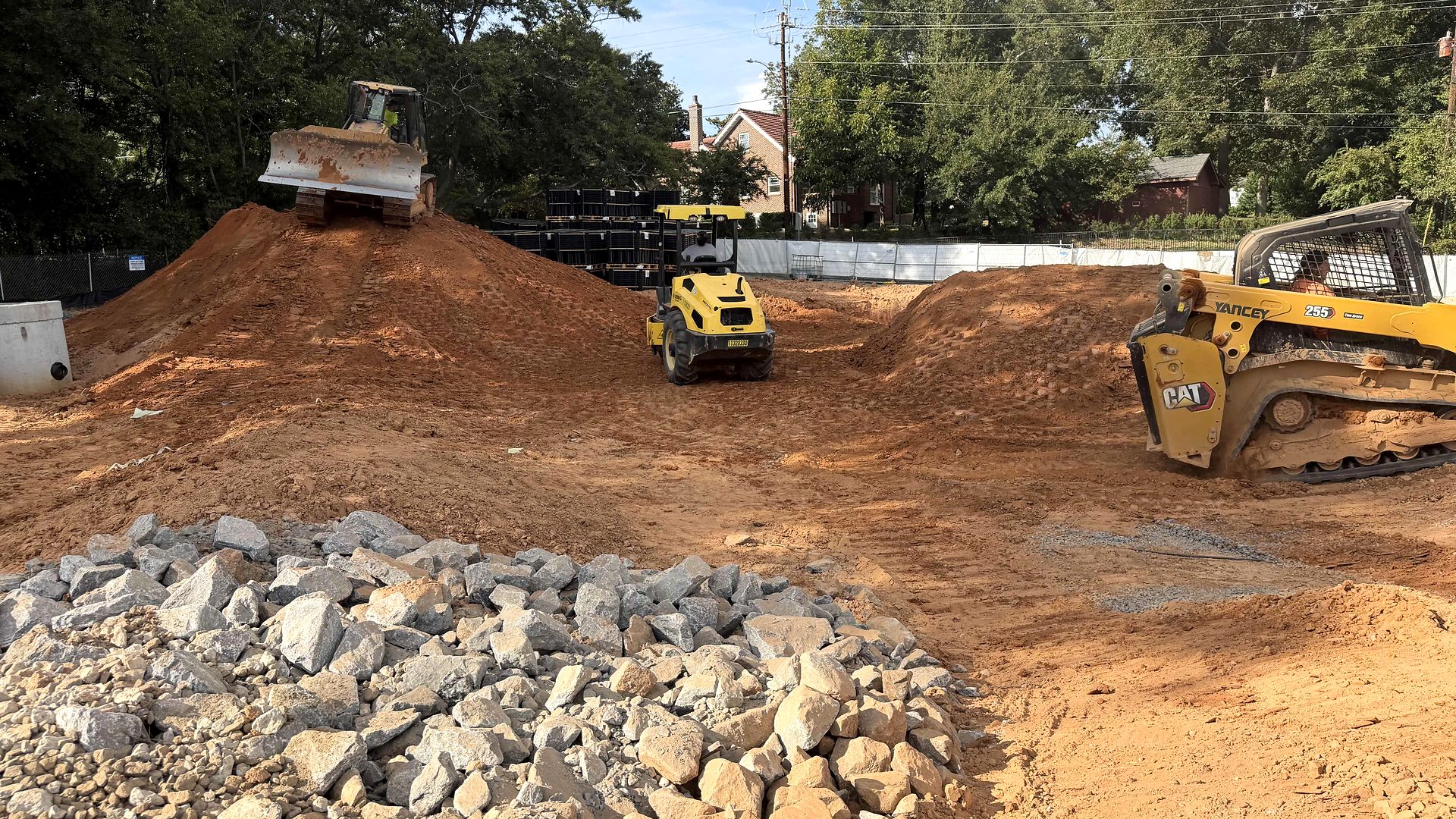 Dozer, roller, and skid steer grading a commercial site in Alpharetta, Georgia