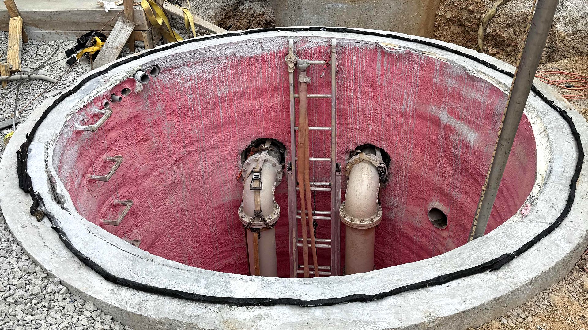 Open precast wet well with a lined interior, discharge pipes, and an access ladder in Blue Ridge, Georgia