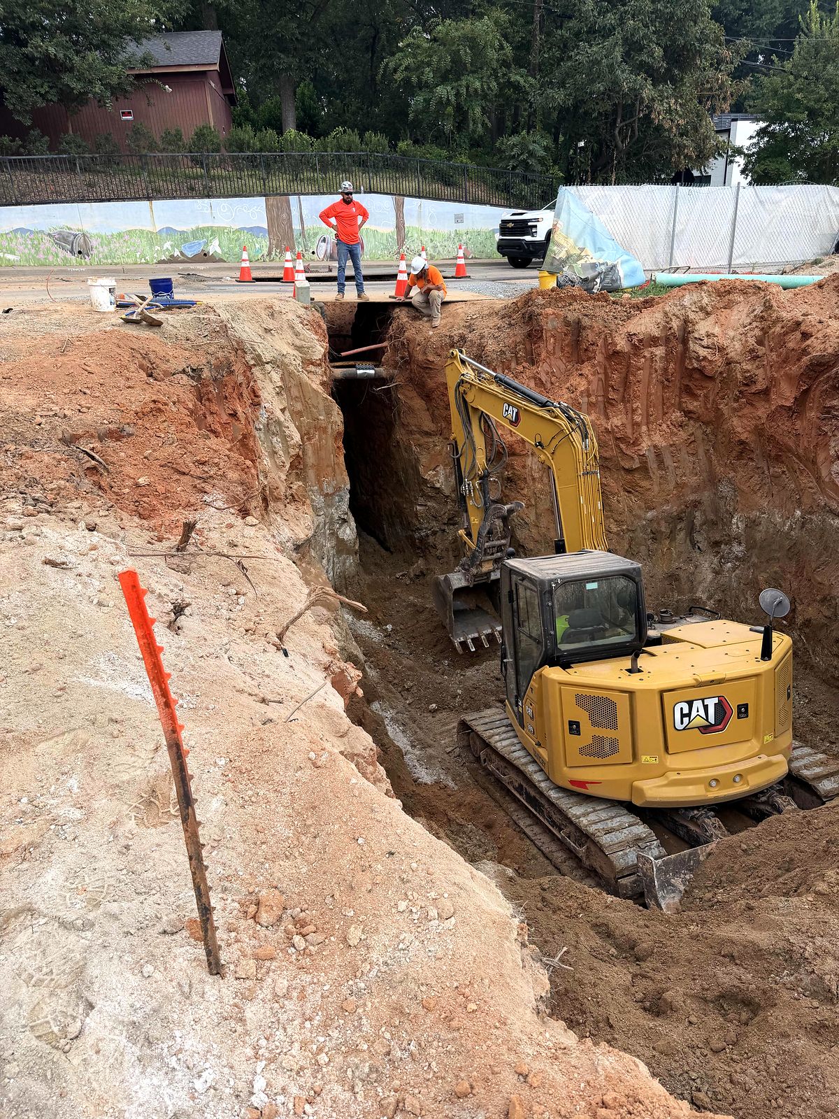 Compact excavator working in a deep utility excavation in Alpharetta, Georgia