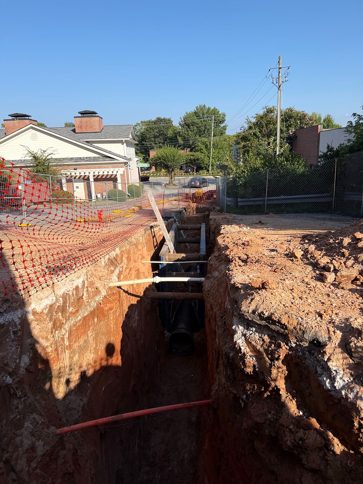 Deep utility trench with a trench box beside existing buildings in Alpharetta, Georgia