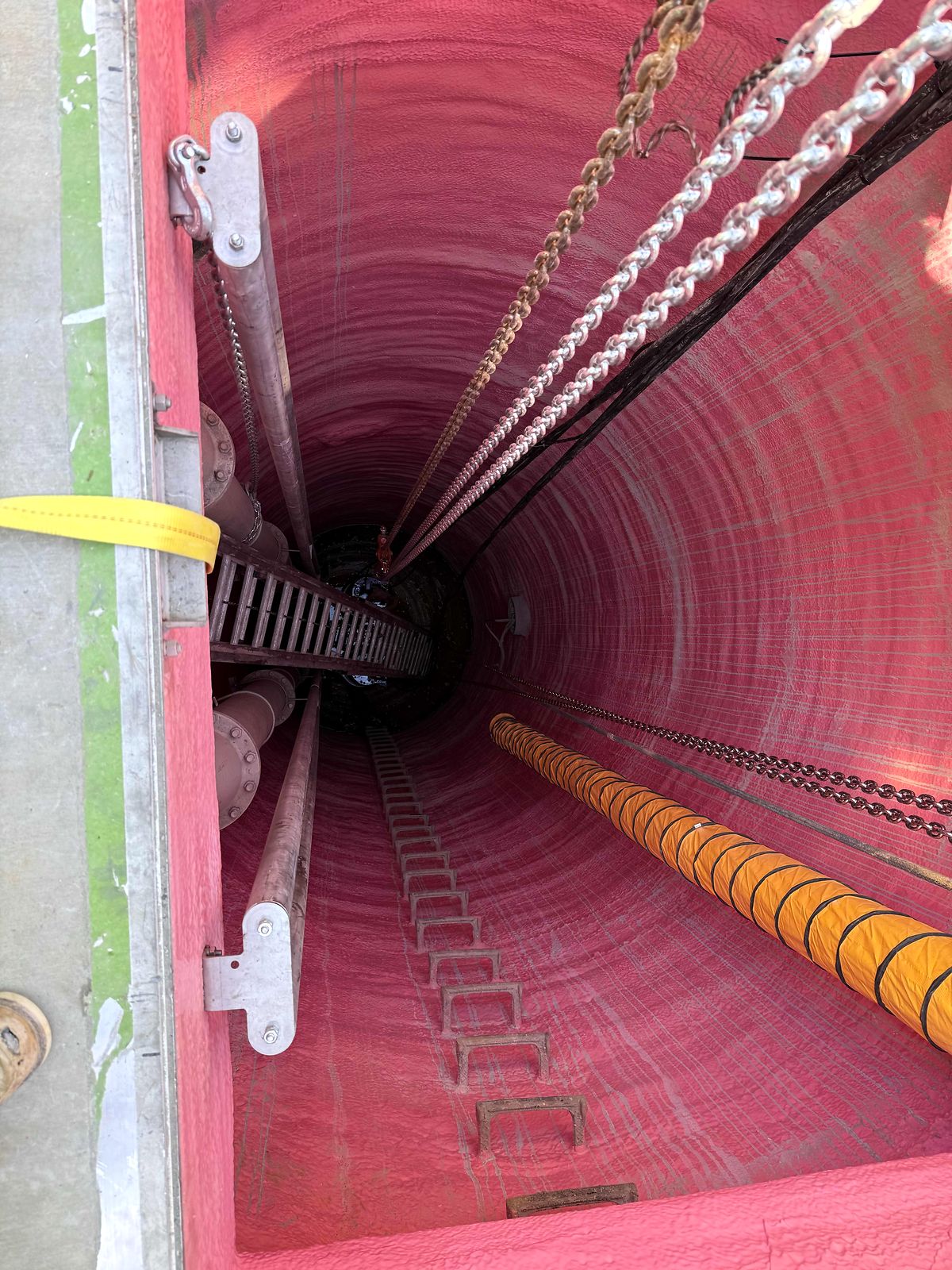 Looking down into the lined wet well with guide rails and a ventilation duct in Blue Ridge, Georgia