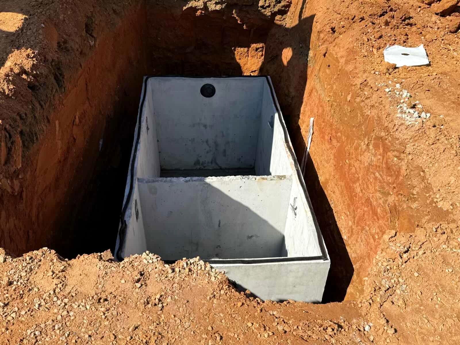 Two-compartment precast concrete tank set in a trench at Twigs Farmers Market