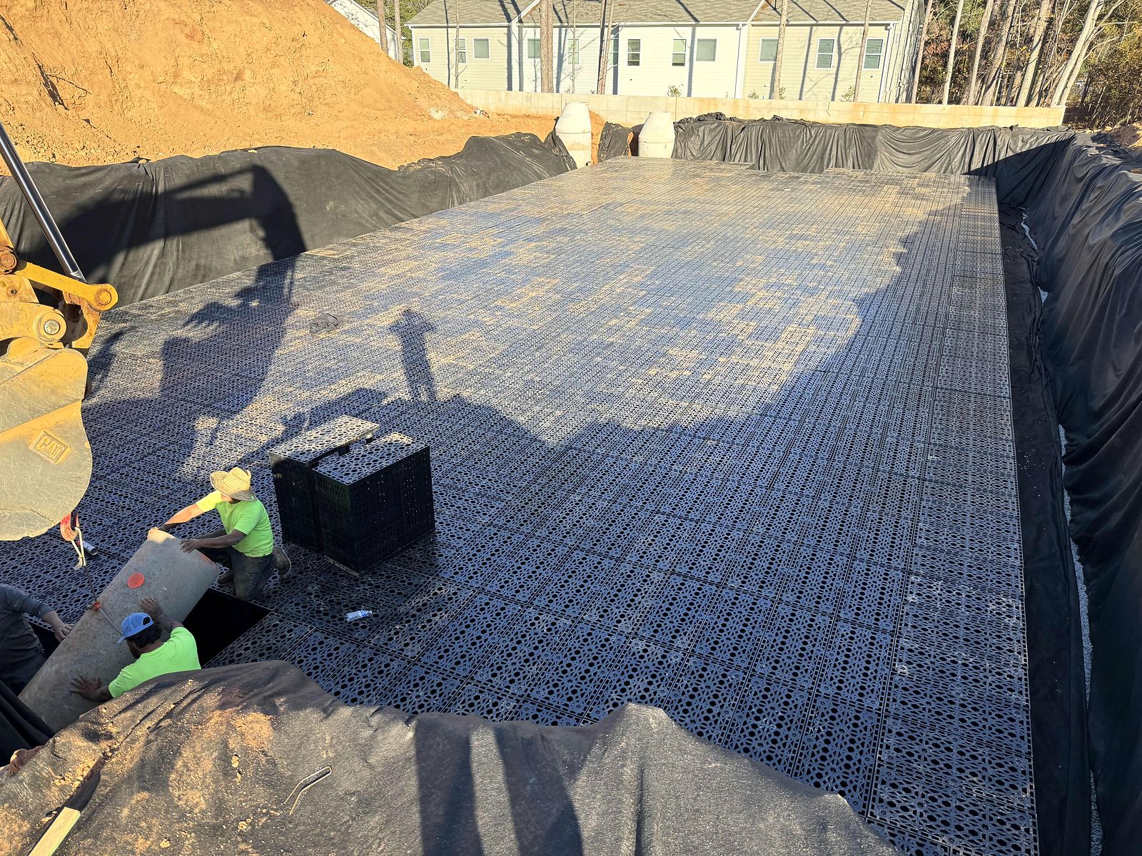 Crew placing modular stormwater storage units and a pipe connection at Twigs Farmers Market