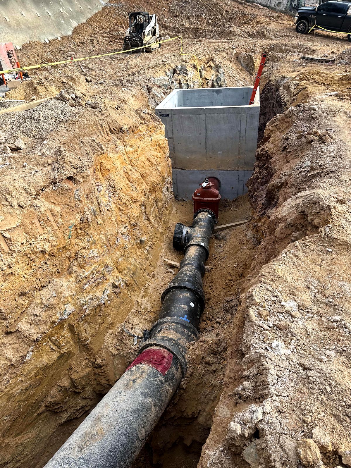 Ductile iron water line and red gate valve leading to a precast vault in Bartow County, Georgia