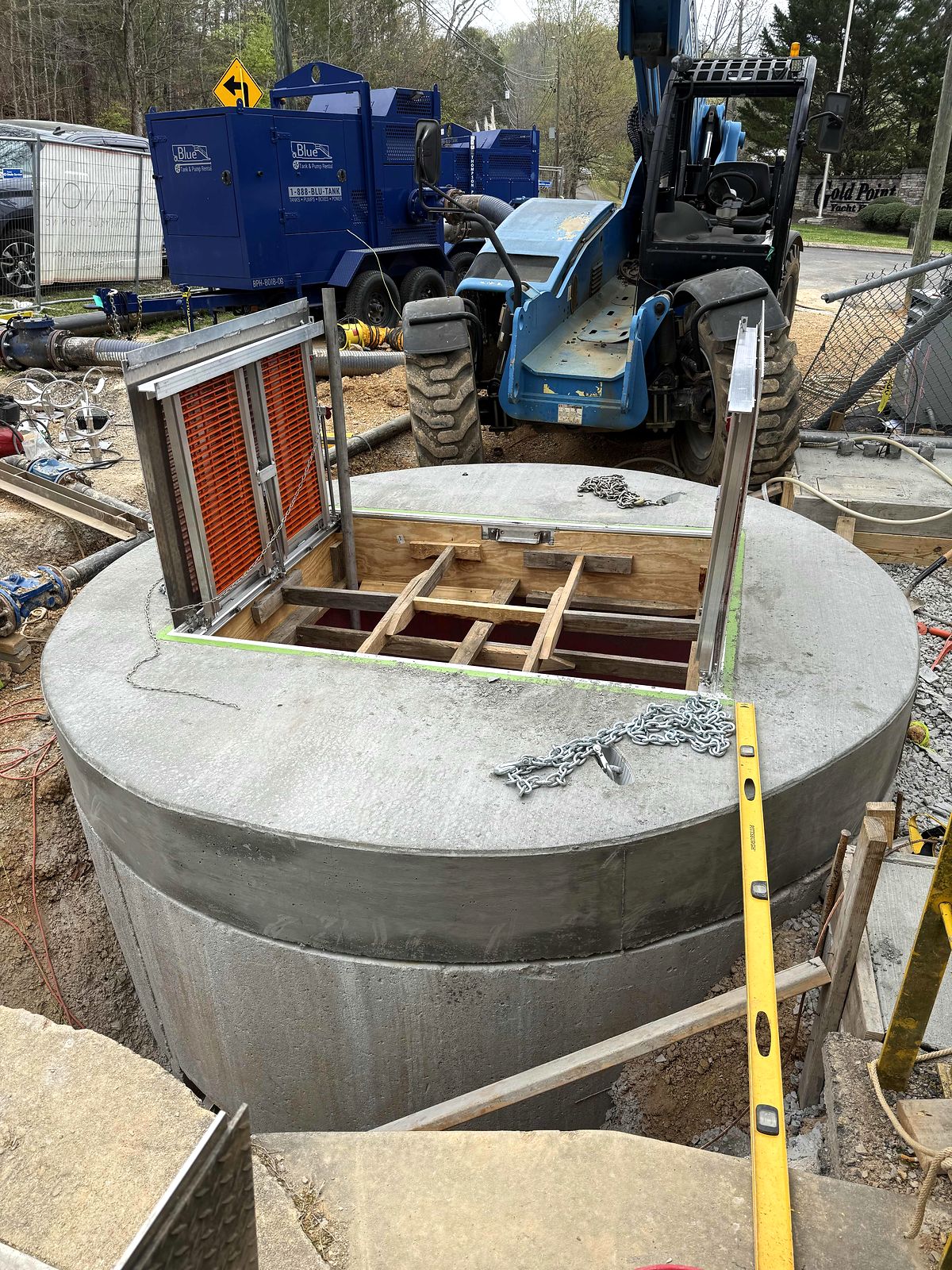 Precast wet well top with hatch framing, with trailer-mounted pumps and a telehandler on site in Blue Ridge, Georgia