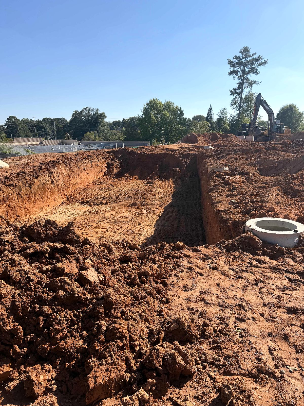 Open excavation with a precast manhole section on a commercial site in Alpharetta, Georgia