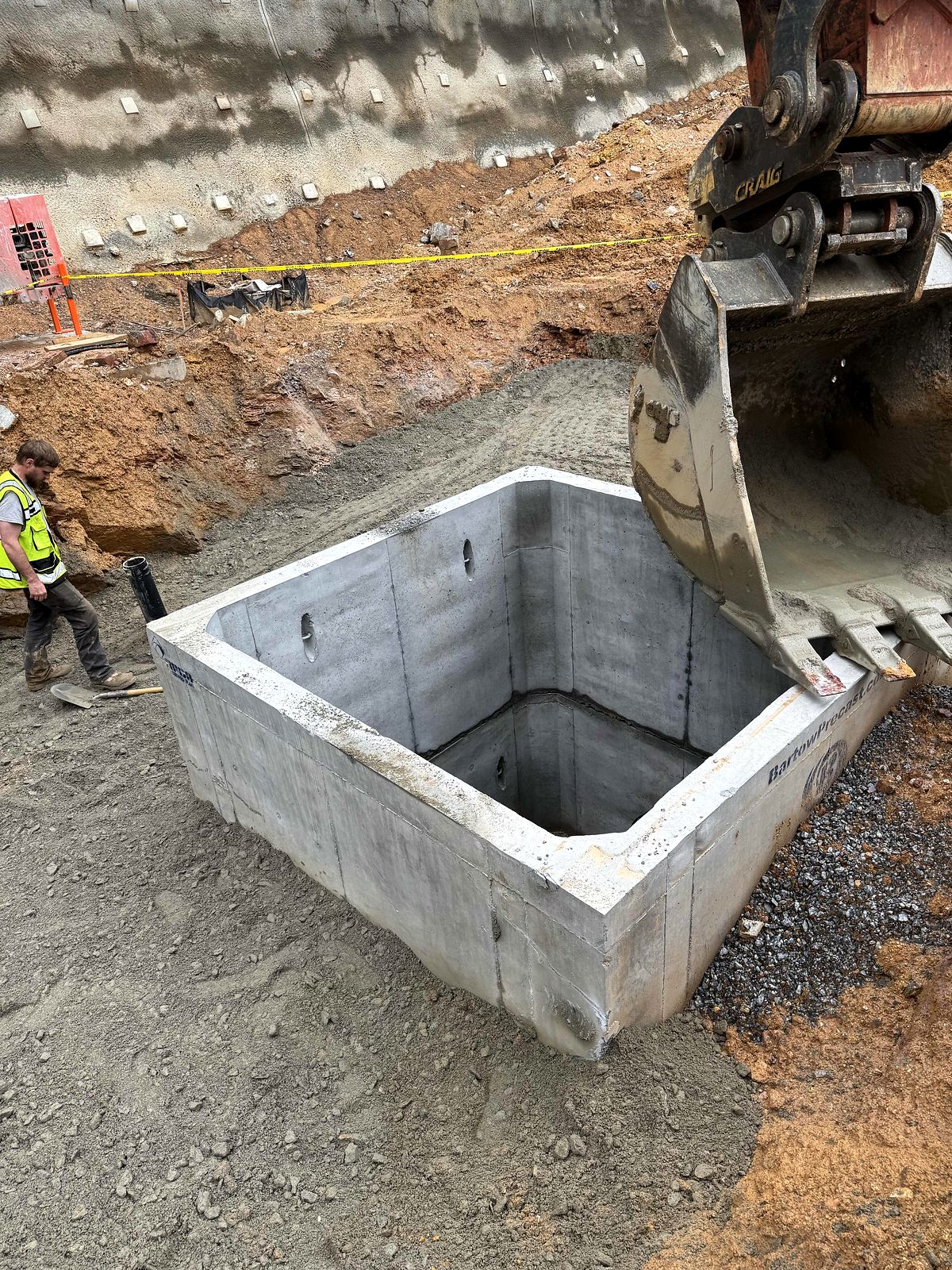 Excavator setting a precast concrete vault in Bartow County, Georgia