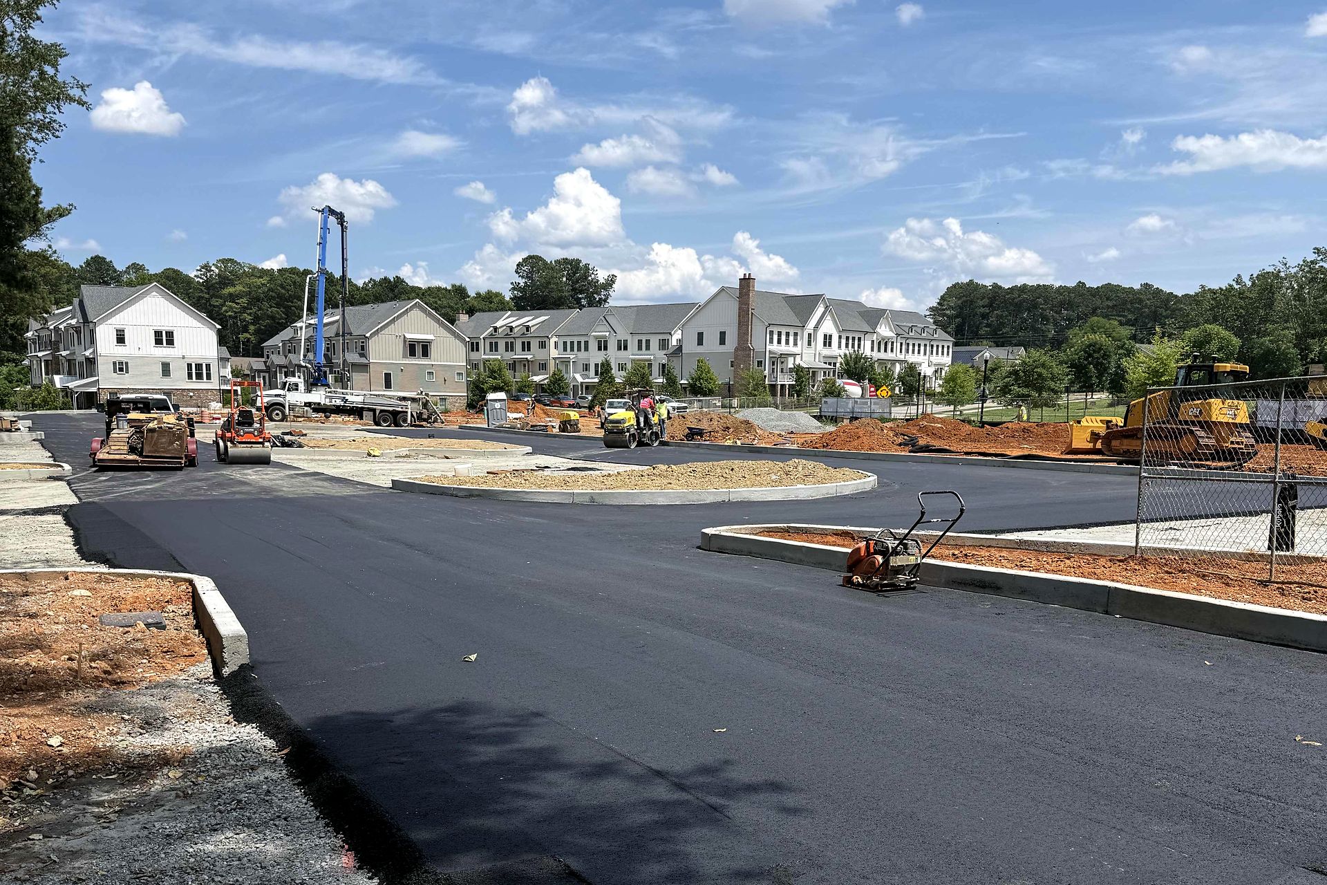 New asphalt paving and concrete curb next to townhomes at Reliant Market District