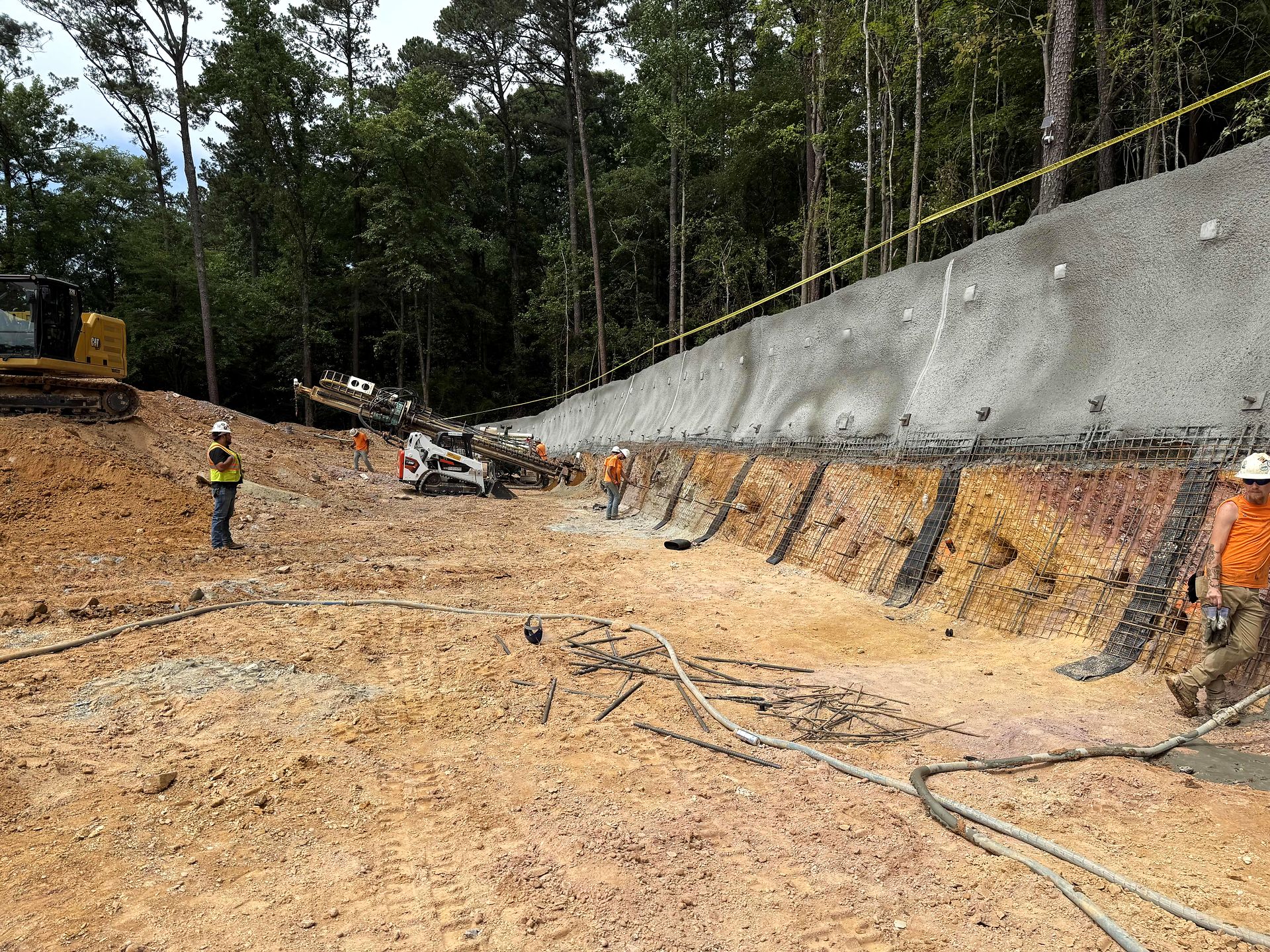 Crew and drill rig working along a shotcrete-faced excavation wall at a water pump station site in Bartow County, Georgia
